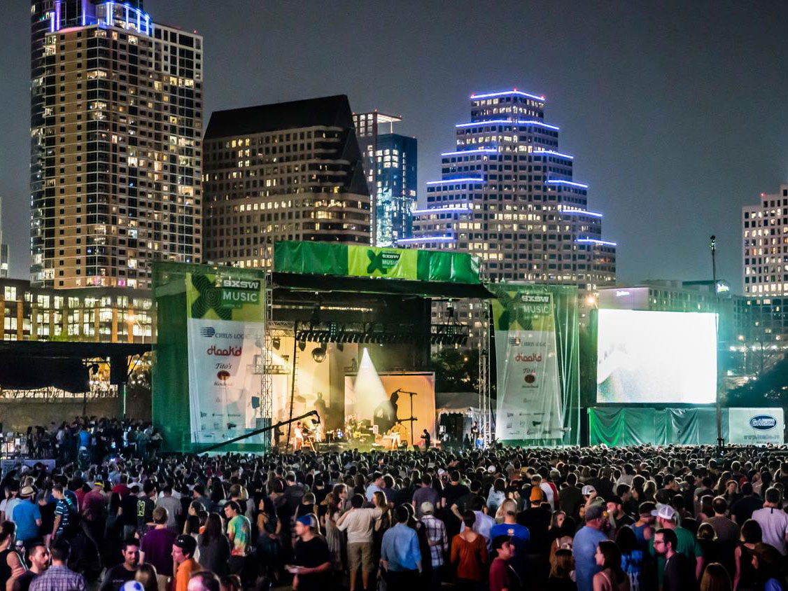 Image of a music festival during SXSW at Auditorium Shores with a skyline view of downtown Austin